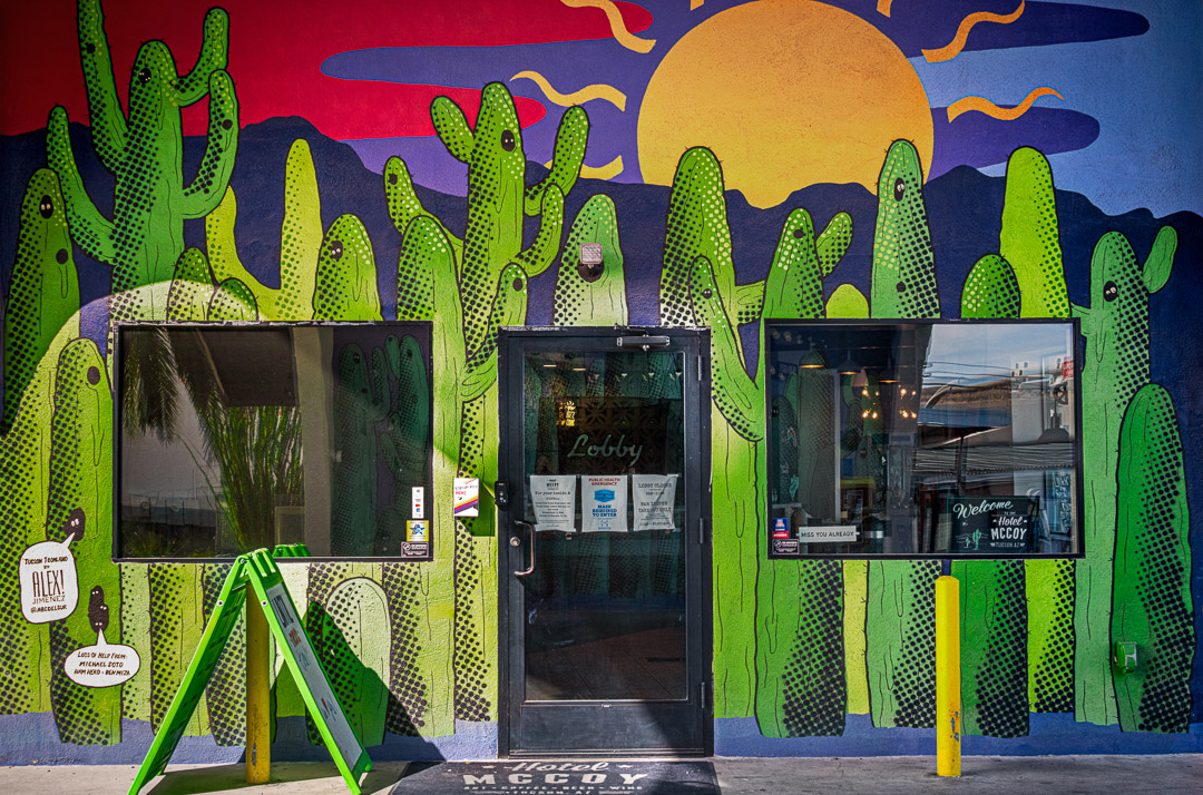 Saguaro mural on side of Hotel McCoy with sun coming up behind mountains. Tuscon.