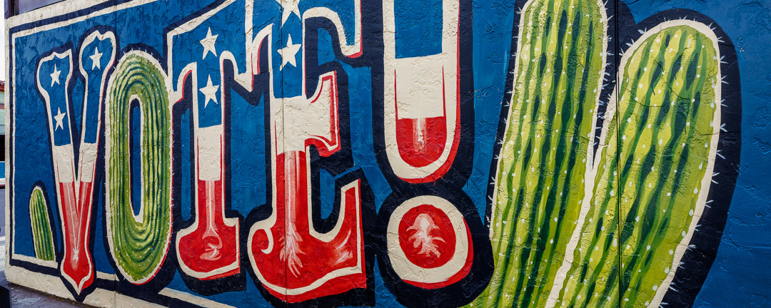 Panoramic image of mural with VOTE! and cactus. Tuscon.